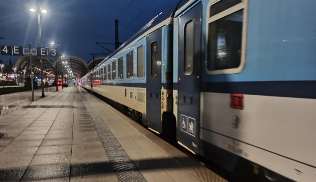 Blauer Zug im Bahnhof. Schräg fotografiert. Am Eingang klar erkennbar: Ein Rollstuhlzeichen