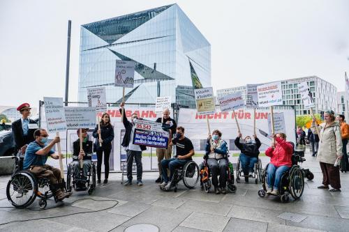Protestierende mit Rollstuhl und Langstock am Bahnhof Berlin